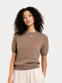Woman wearing a brown top and beige skirt on a white background #color_taupe