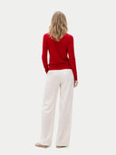 back view of a woman wearing a red sweater and white pants on a white background #color_chili-pepper