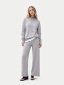 Woman wearing a gray hoodie and pants on a white background #color_high-rise