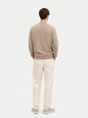 back view of a Man wearing a beige sweater and light-colored pants on a white background #color_taupe