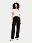 Woman wearing a white t-shirt and black straight jogger on a white background #color_black