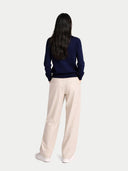 back view of person wearing a navy sweater and beige pants on a white background color_mood-indigo