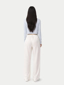 Person wearing a light blue top and white pants on a white background #color_ice-flow
