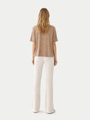 back view of a woman wearing a brown top and white pants on a white background #color_timber-wolf