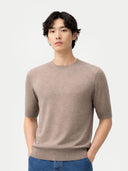 Man wearing a brown sweater and blue jeans against a white background #color_timber-wolf