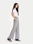 side view of a woman wearing a white top and gray wide-leg pants on a white background  #color_high-rise