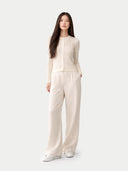 Woman wearing a beige outfit on a white background #color_whisper-white