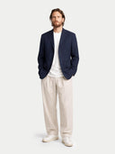 front view of Man wearing a navy blazer, white shirt, and beige pants on a white background #color_navy