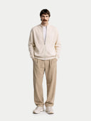 front view of a man wearing a cream-colored sweater and beige pants on a white background #color_marshmallow