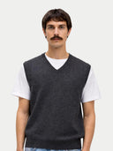 Man wearing a dark gray sweater vest over a white shirt on a light gray background #color_charcoal