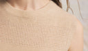 Close-up of a beige sleeveless top with a textured pattern. desktop