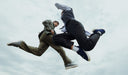 Two people in formal attire mid-air against a cloudy sky. desktop