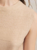 Close-up of a beige sleeveless top with a textured pattern. mobile
