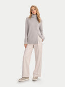 front view of a woman wearing a gray turtleneck sweater and light-colored pants on a white background #color_chateau-gray