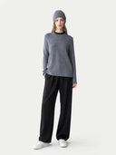 Person wearing a gray sweater and black pants on a white background #color_stone-gray