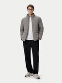 Man wearing a gray puffer jacket, white shirt, black pants, and gray shoes on a white background #color_dim-gray