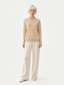 front view of a woman wearing a beige cardigan and white pants on a white background#color_beige