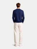 back view of a navy sweater and white pants on a light gray background #color_navy-blazer
