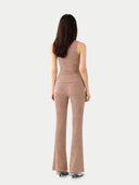 back view of a woman wearing a beige sleeveless top and pants on a white background #color_timber-wolf