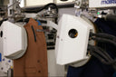 A camel cashmere coat moving through an automated sewing and inspection machine