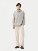 Person wearing a gray sweater and beige pants on a white background  #color_dawn-blue