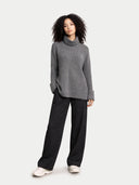 Person wearing a gray turtleneck sweater and black pants on a white background #color_steel-gray