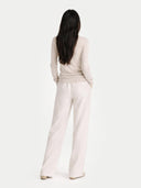 back view of a person wearing a light pink outfit with wide-leg pants on a white background #color_warm-grey