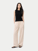 front view of a black sleeveless top and beige pants on a white background #color_black