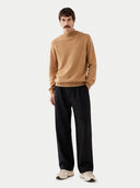 front view of Man wearing a beige sweater and black pants on a white background #color_sheepskin