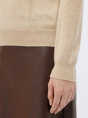 close up of a beige sweater long sleeve and brown leather skirt #color_beige
