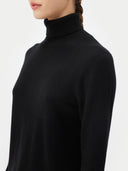 close up of a black turtle neck sweater on a light gray background #color_black