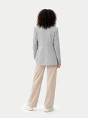 back view of Person wearing a light gray blazer and beige pants on a white background #color_vapor-blue