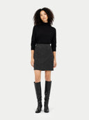 Woman wearing a black turtleneck, gray skirt, and black knee-high boots on a white background #color_charcoal
