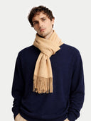 Man wearing a navy sweater and beige scarf on a light gray background #color_toasted-almond