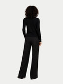 back view of a woman wearing a black outfit on a white background #color_black