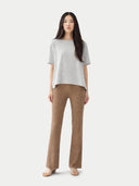 front view of Woman wearing a light gray top and brown pants on a white background #color_wind-chime