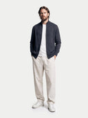 Man wearing a dark gray cardigan, white t-shirt, beige pants, and white sneakers on a white background #color_charcoal