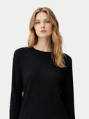 Woman wearing a black long-sleeve top against a white background #color_black