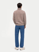 back view of a person wearing a beige sweater and blue jeans on a white background #color_taupe