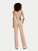 back view of Woman wearing a beige jumpsuit on a white background #color_beige