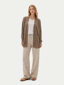 Woman wearing a brown cardigan, white top, and beige pants on a white background #color_taupe