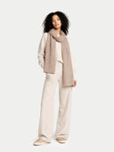 Woman wearing a beige scarf and pants on a white background #color_taupe