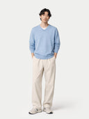 front view of a person wearing a light blue sweater and beige pants on a white background #color_light-blue