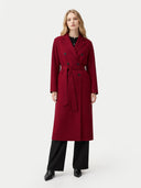 Woman wearing a red coat with a belt on a white background #color_bordeaux