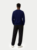 back view of a Person wearing a navy sweater and black pants on a white background #color_navy
