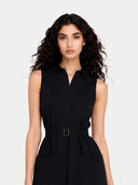 Woman wearing a black sleeveless dress with a belt on a white background #color_black