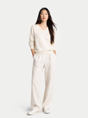 front view of a woman wearing a cream-colored sweater and pants on a white background #color_off-white