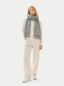 Woman wearing a gray scarf and beige pants on a white background  #color_dim-gray