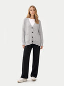 Woman wearing a gray cardigan, white shirt, black pants, and white sneakers on a white background #color_high-rise