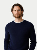 Man wearing a navy sweater against a plain background #color_navy-blazer